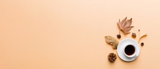 Flat lay composition with colorful Autumn cup of coffee and leaves on a color background. top view