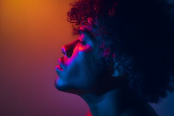 Fototapeta premium Man with afro looking up with vibrant red, orange and blue lighting