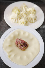 Making khinkali dough with special tool for filling