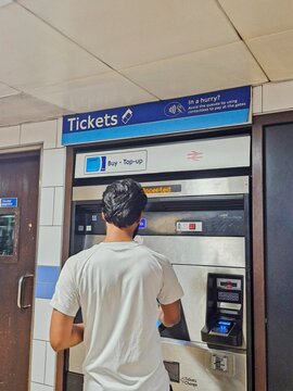 LONDON-JULY 14 2025:Unidentified man purchases Oyster ticketless journey card at Green Park station. The rechargeable card usable for public transport in London on Tube, buses and other TfL services.