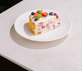 Delicious dessert slice with fruits served on a white plate at a modern café