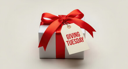 Silver gift box with red ribbon and tag saying giving tuesday