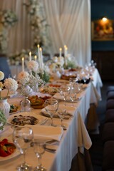 Elegant wedding banquet table with flowers, candles and festive food arrangement