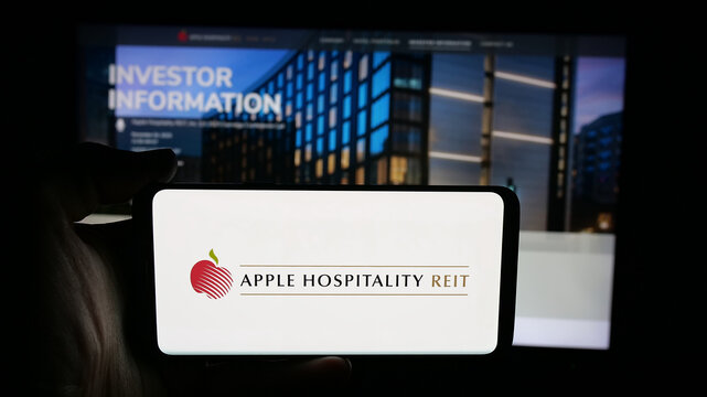 Stuttgart, Germany - 11-08-2025: Person holding cellphone with logo of US company Apple Hospitality REIT Inc. on screen in front of webpage. Focus on phone display.