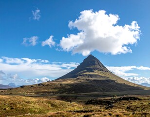 A triangular mountain rising from a grassy landscape under a cloudy sky
