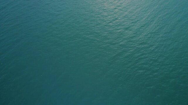 A serene close-up of gentle water waves in Banswara, Rajasthan, reflecting sunlight like a giant mirror, creating a peaceful ocean-like surface.