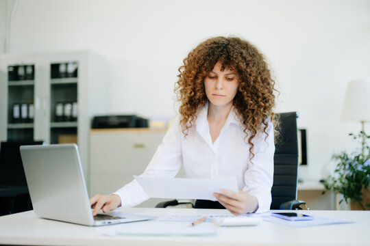 Confident business expert attractive smiling young woman holding digital tablet on desk