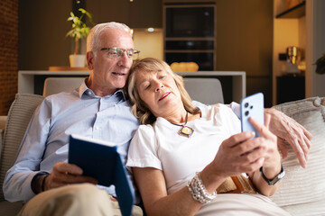 Senior couple relaxing on couch with a smartphone together