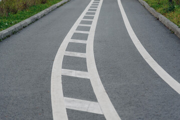 Obraz premium white road markings on sidewalk, separating bike path and pedestrian path
