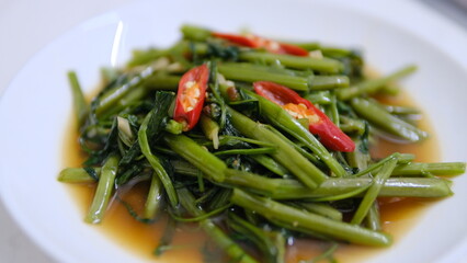 Table top view stir-fried Chinese morning glory isolated on white background.