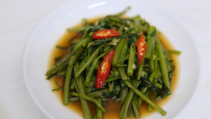 Table top view stir-fried Chinese morning glory isolated on white background.