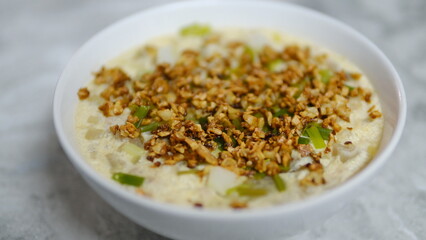 Rice porridge with fish and vegetable in black bowl,Thai style food