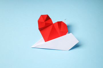 Heart origami on a white boat, light blue backdrop