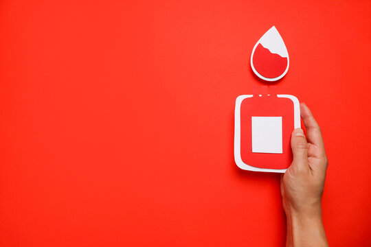 Hand holding a paper cutout representing blood donation