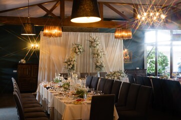 Elegant wedding banquet hall with white floral arch and prism light effects