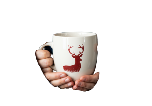 pale hands in chunky sapphire blue nordic knitwear hold a steaming white christmas mug with a reindeer decal against a white background, macro detail shot. concept of scandinavian hygge and winter