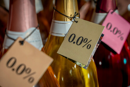 Paris, France - 11 19 2025: Detail of the neck of three bottles of rosé, white and red wine with a 0.0% alcohol-free label in a store - Powered by Adobe