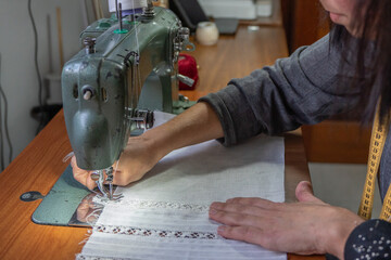Woman sewing fabric with a vintage sewing machine