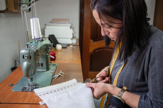 Professional woman fashion designer cutting fabric at workspace