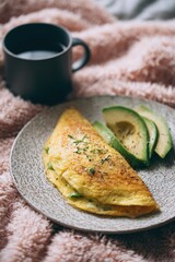 Omelet with Avocado Slices and Coffee Mug on Plush Blanket, Cozy Morning Still Life.