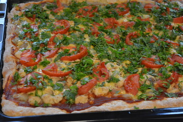 Food, groceries, homemade fresh baked goods. Large pizza with chicken pieces, tomato slices, cheese, and fresh greens.