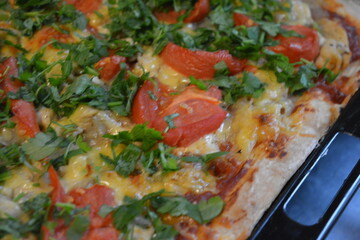 Food, groceries, homemade fresh baked goods. Large pizza with chicken pieces, tomato slices, cheese, and fresh greens.