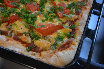 Food, groceries, homemade fresh baked goods. Large pizza with chicken pieces, tomato slices, cheese, and fresh greens.