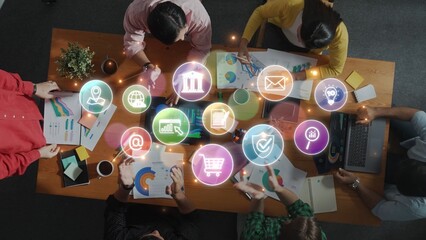 A diverse group of professionals collaborates in an office, analyzing charts and data while surrounded by digital symbols representing modern business concepts. Raster