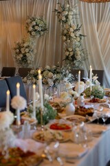 Elegant wedding reception hall with floral arch, candles and decorated banquet tables
