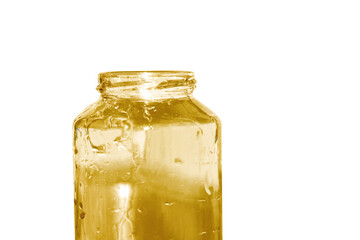 Honey being poured into a jar against a white background