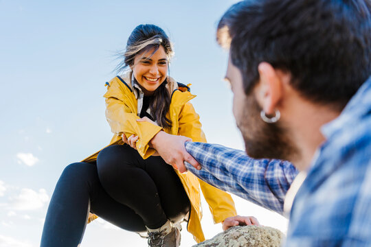 Smiling girlfriend pulling hand of boyfriend