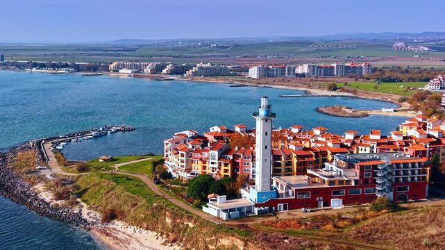Beautiful residential neighborhood with a lighthouse at the coast of the sea. Lovely pier with some boats nearby. Bulgaria.
