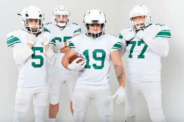 Full-length portrait of American football players in uniform on white