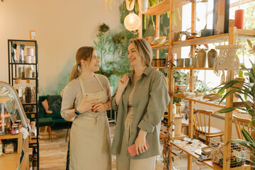 Smiling waitress and manager talking to each other in organic cafe