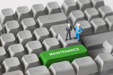 Miniature Business Figures Standing on Keyboard Button with Text Maintenance. Symbolizing system upkeep, operational support, technical service, and ongoing business processes.