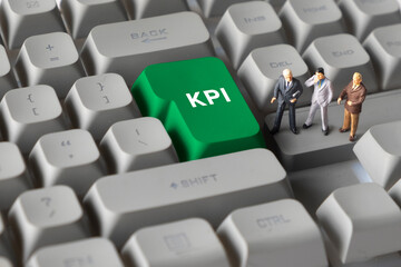Miniature Business Figures Standing on Keyboard Button with Text KPI. Illustrating key performance indicators, business measurement, productivity tracking, and organizational goals.