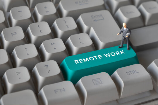 Miniature Business Figures Standing on Keyboard Button with Text Remote Work. Symbolizing work-from-home culture, digital communication, hybrid jobs, and modern workplace flexibility. - Powered by Adobe
