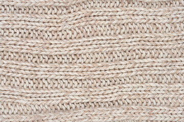 A full-frame, close-up abstract background of a cozy, beige or light gray ribbed knit fabric texture with visible wool fibers and horizontal stitches