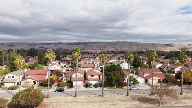 High-angle panning view from a drone over Alameda Creek Trail showcases trees, bike paths, and surrounding homes.