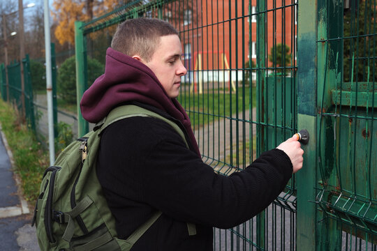 Young student with backpack unlocking security gate