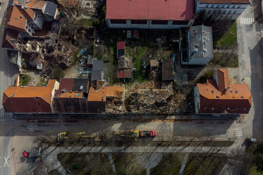 Aerial view of a building reduced to rubble amidst structures with orange tiled roofs and bare trees, a landscape marked by destruction, Petrinja, Sisak-Moslavina County, Croatia.