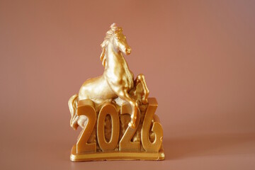 The figure of a horse and the date 2026 on a brown background. A holiday date.