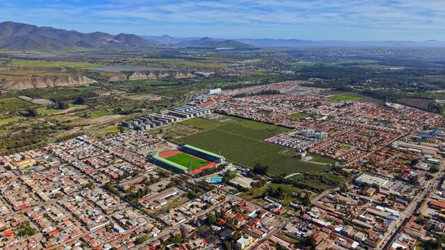 Flyover establishing shot of the city of Ovalle on a sunny day in the Limari Valley, producer of Chilean pisco, northern Chile.
