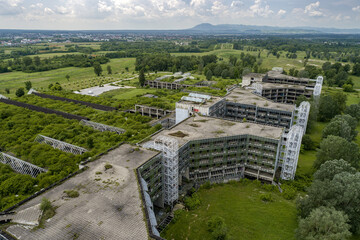 Aerial view of a derelict, overgrown structure stands as a stark reminder of forgotten times, amidst the vibrant greens of nature reclaiming its space, Zagreb, Croatia.