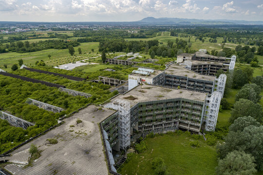 Aerial view of a derelict, overgrown structure stands as a stark reminder of forgotten times, amidst the vibrant greens of nature reclaiming its space, Zagreb, Croatia.
