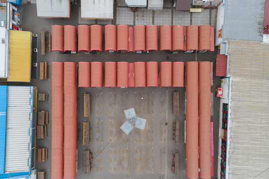 Aerial view of neatly arranged cylindrical objects casting shadows on the ground, an industrial ballet of form and function, Zagreb, Croatia.