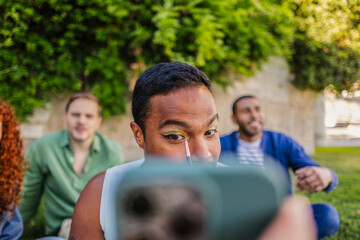 Gender fluid person applying makeup filming vlog