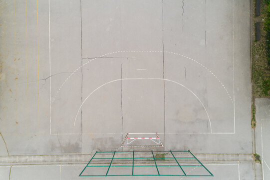 Aerial view of the desolate handball court with faded lines and worn concrete, a silent testament to countless games played, Zagreb, Croatia.