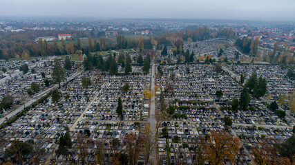 Aerial view of Mirogoj Cemetery under a muted sky, the intricate patterns of graves and monuments creating a somber tapestry stretching towards the horizon, Zagreb, Croatia.