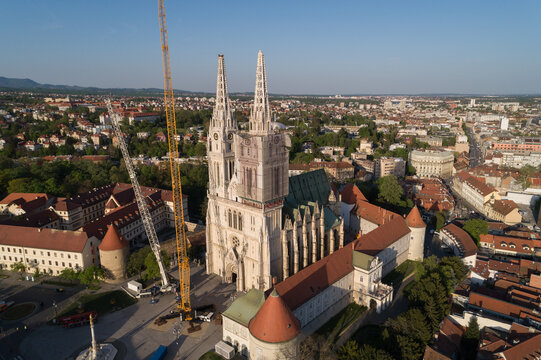 Aerial view of the majestic Zagreb Cathedral stands tall amidst the urban sprawl, its spires piercing the sky, a testament to architectural grandeur, Zagreb, Croatia.